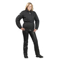 A woman standing and posing in black leather motorcycle trousers and boots.